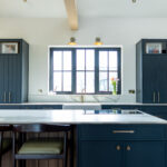 Blue kitchen with white island and sink