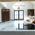 Blue kitchen shot of beautiful stone island into living area