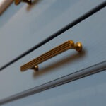 close up of blue drawers with brass handles